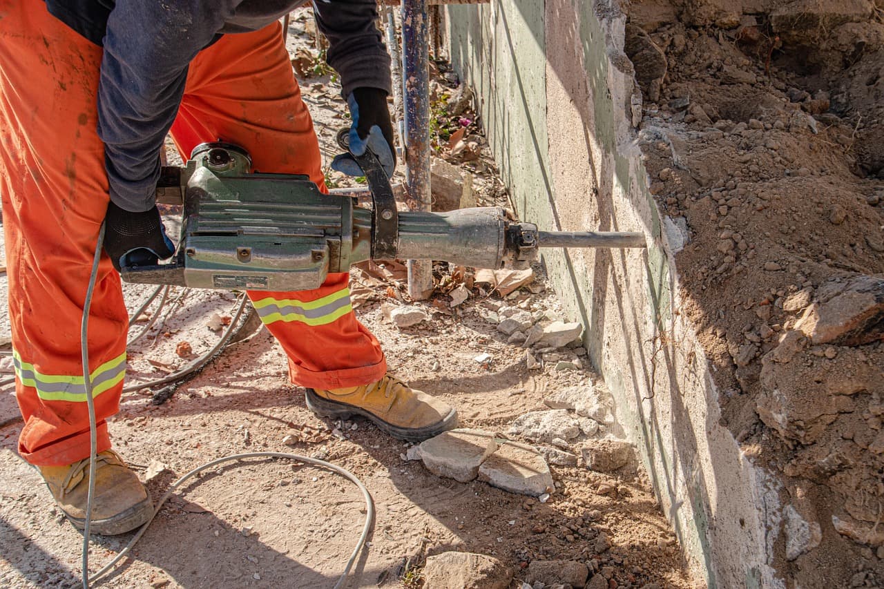 A roofer reviewing a digital estimate on a tablet at a residential job site